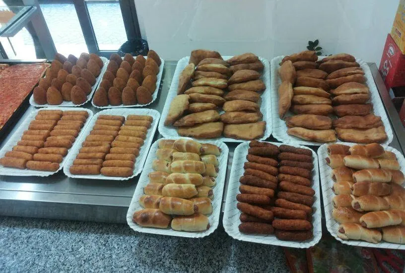 Il banco della rosticceria con i vassoi di arancini, crocchette e calzoni