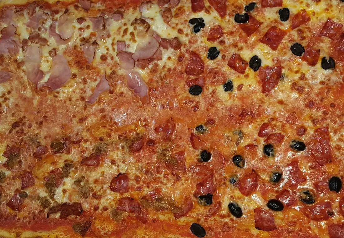 Una teglia rossa appena sfornata, con olive nere
